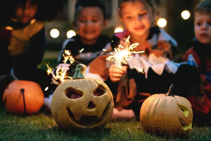 kids with sparklers and jack-o-lanterns